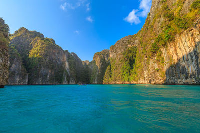 Scenic view of sea and mountains against blue sky