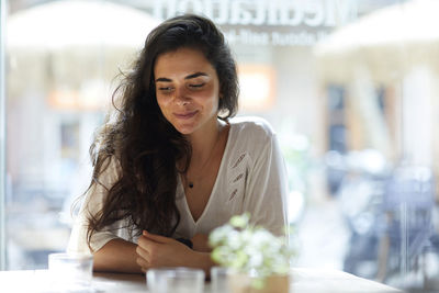 Portrait of young woman sitting in city