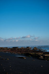 Scenic view of beach against blue sky