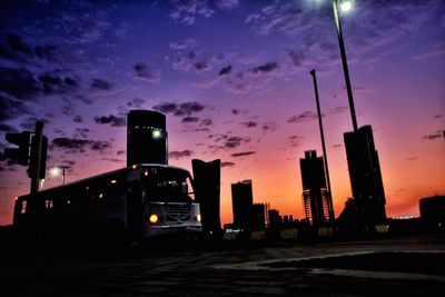 Low angle view of illuminated skyscrapers against sky at sunset