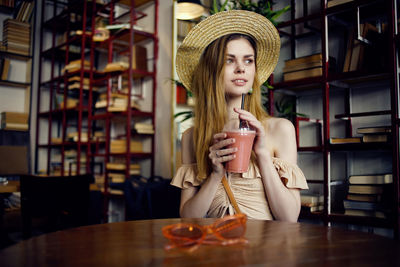 Young woman drinking glass on table