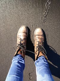 Low section of man standing on road