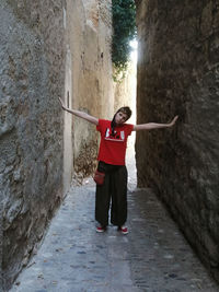 Full length rear view of woman standing on walkway