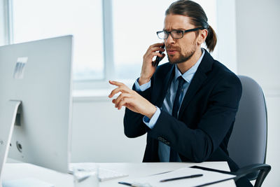 Man using mobile phone while sitting on table