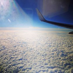 Cropped image of airplane wing over cloudscape