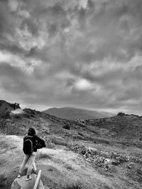 Rear view of man on landscape against sky