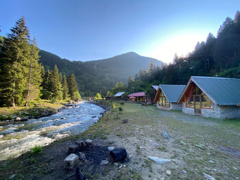 Scenic view of houses by mountains against sky