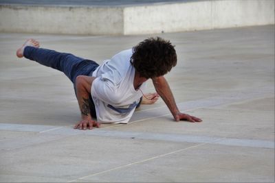 Young man exercising on footpath
