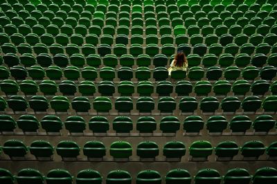 Woman sitting on seat in stadium