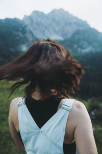 Rear view of woman standing against mountain