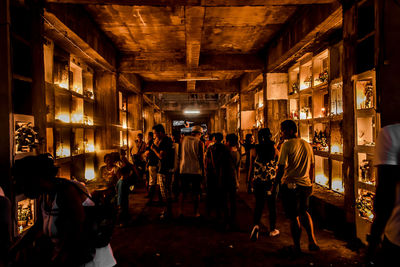 Group of people at illuminated market at night