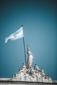 Low angle view of statue against clear blue sky