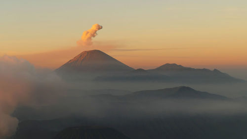 Scenic view of volcanic mountain against sky during sunset