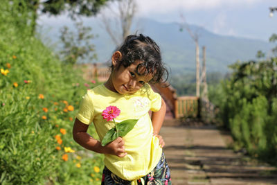 Full length of woman standing by flowering plants