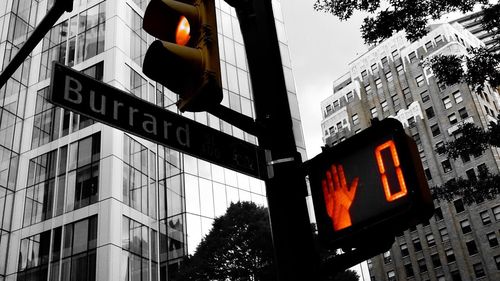 Low angle view of road sign against buildings in city