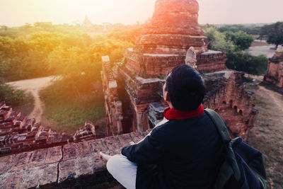 Rear view of a woman standing against temple