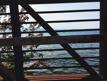 Close-up of text on tree against sea