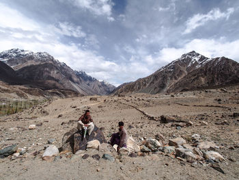 People walking on mountain against sky