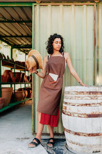 Full length portrait of smiling woman standing outdoors