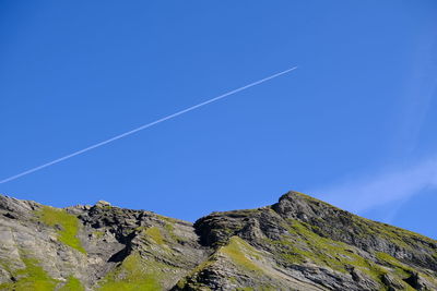 Low angle view of vapor trail against clear blue sky