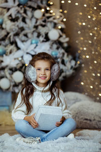 Portrait of cute baby girl sitting on snow