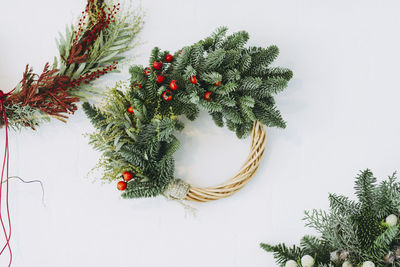 Close-up of christmas wreath over white background