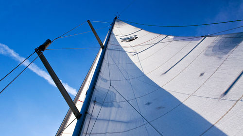 Low angle view of sailboat against blue sky