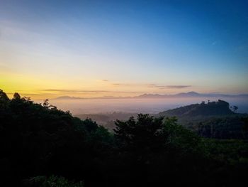 Scenic view of silhouette mountains against sky at sunset