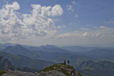 People standing on mountain against sky