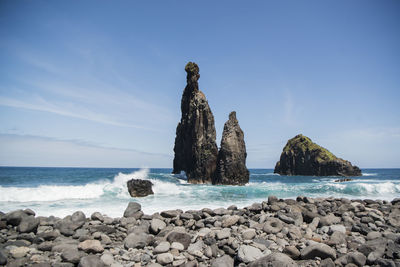 Scenic view of rocks on beach against sky