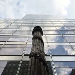 Low angle view of modern building against cloudy sky