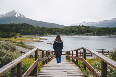 Rear view of woman looking at lake against mountain