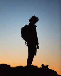 Low angle view of silhouette woman against sky at sunset