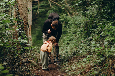 Rear view of a woman standing in forest