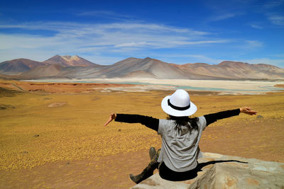 Rear view of woman wearing hat against mountains