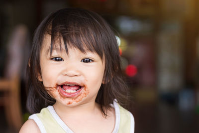 Portrait of happy cute baby girl with messy face