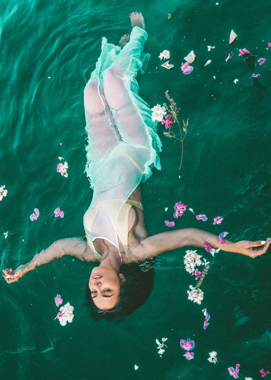 HIGH ANGLE VIEW OF WOMAN SWIMMING IN SEA