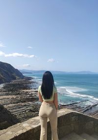 Rear view of woman looking at sea against sky