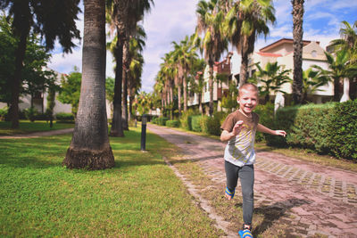 Full length of smiling boy running in yard