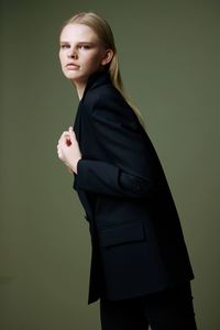 Young woman standing against wall