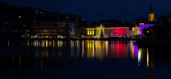 Illuminated buildings in water at night