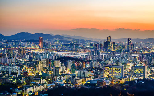 High angle view of illuminated cityscape against sky at dusk