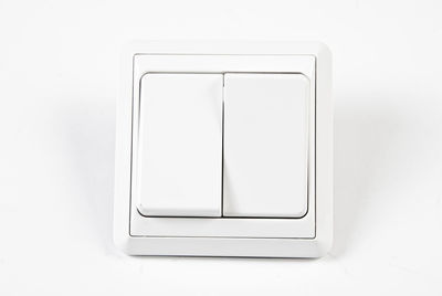 Close-up of light switches on white wall at home
