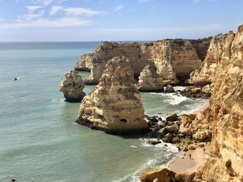 Scenic view of rocks on sea against sky