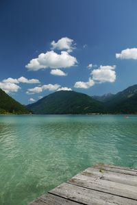 Scenic view of lake by mountains against sky