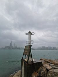 Lighthouse by sea against sky