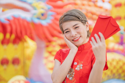 Portrait of a smiling girl holding red umbrella