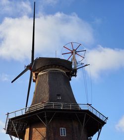 Low angle view of traditional windmill against sky