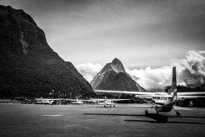 Helicopters on airport runway against mountains and sky