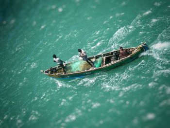 High angle view of people riding on boat over sea